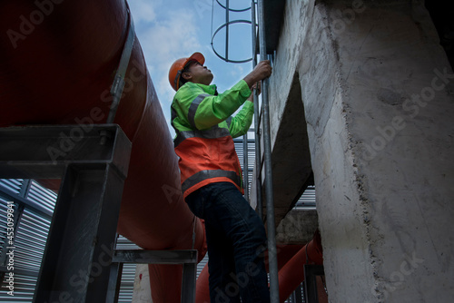 person walking down the stairs. construction workers on a site. engineer under checking the industry cooling tower air conditioner is water cooling tower air chiller HVAC of large industrial building 