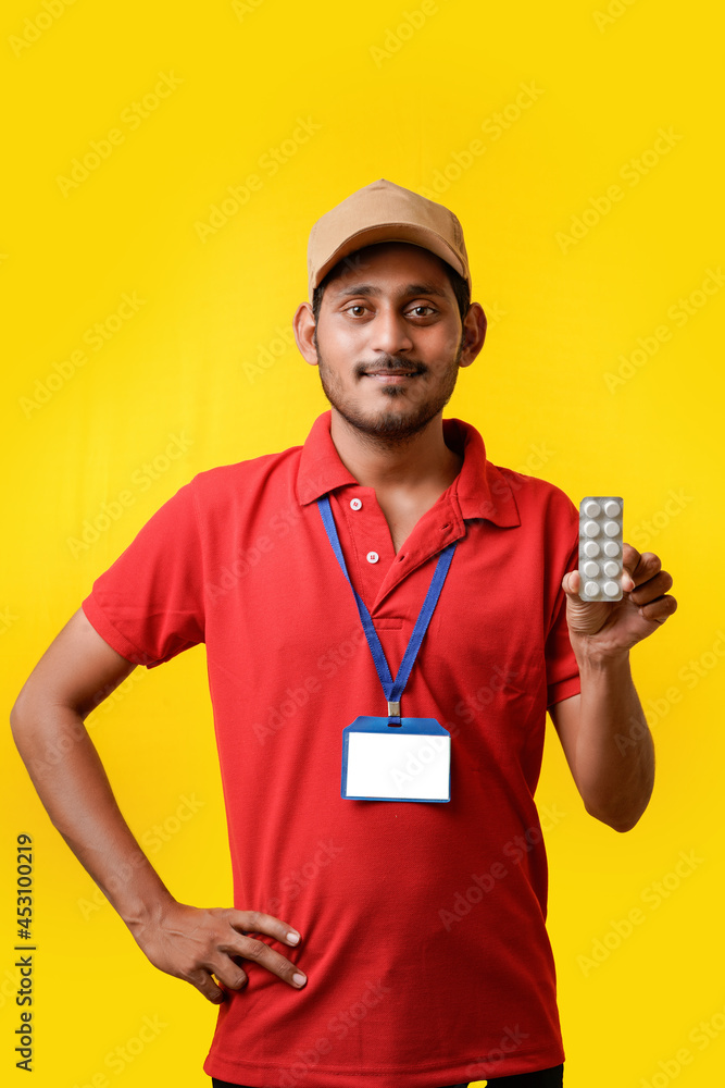 online medicine concept : Indian delivery man holding medicine strip in hand online medicine concept : Indian delivery man holding medicine strip in hand