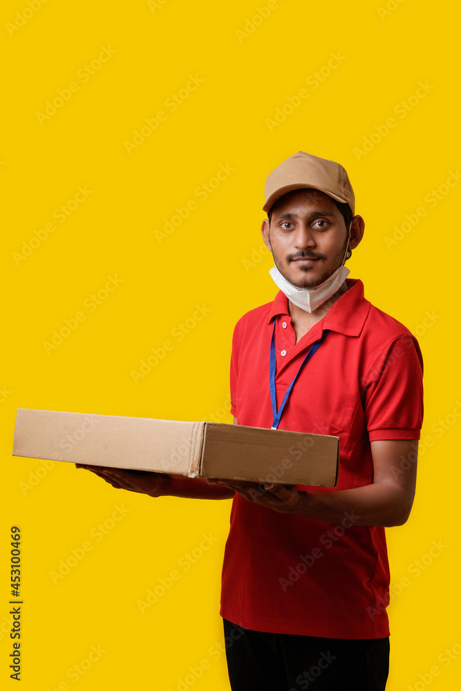 Delivery Man Wearing Medical Mask and hold Box in Hands. Delivery Boy. safe delivery concept. Delivery Man Wearing Medical Mask and hold Box in Hands. Delivery Boy. safe delivery concept.