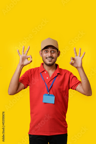 Happy indian man in t-shirt and showing expression isolated over yellow background.