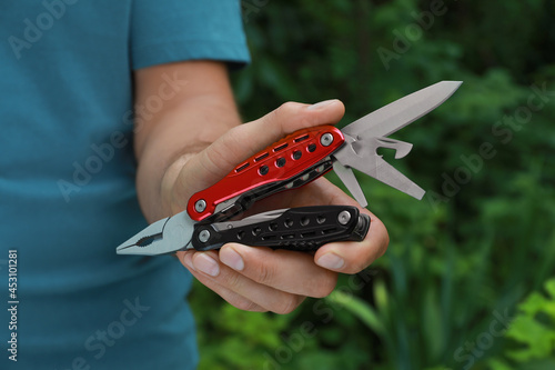 Canvastavla Man holding compact portable multitool outdoors, closeup