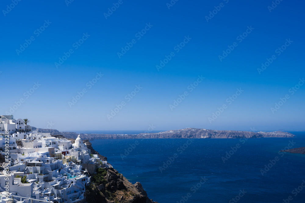 Scenic cityscape of Thira. city on the hill. White architecture. Santorini island, Greece. Luxury tourism. Caldera sea view.