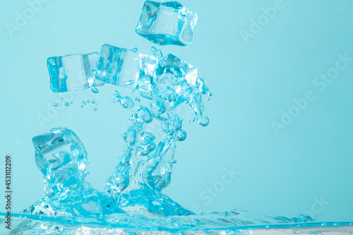 ice cubes with water splashing on blue background