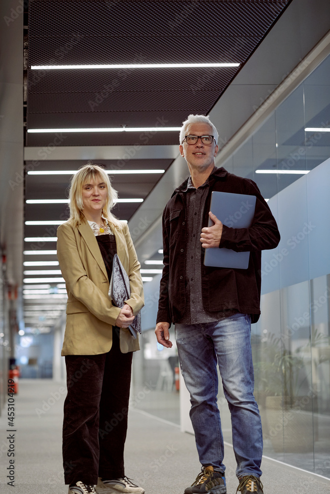 Businessman and businesswoman standing at corridor Businessman and businesswoman standing at corridor