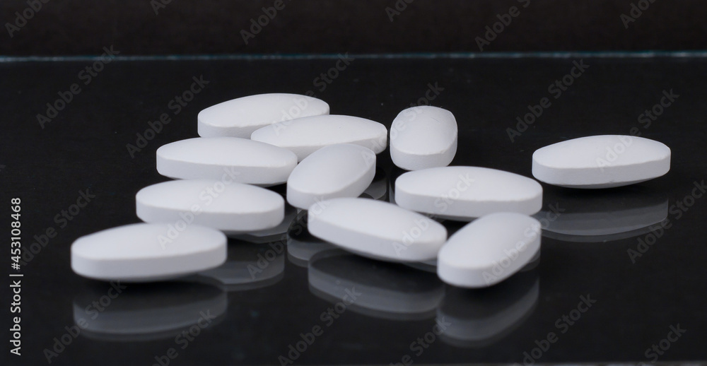 Pills scattered on a black table Pills scattered on a black table