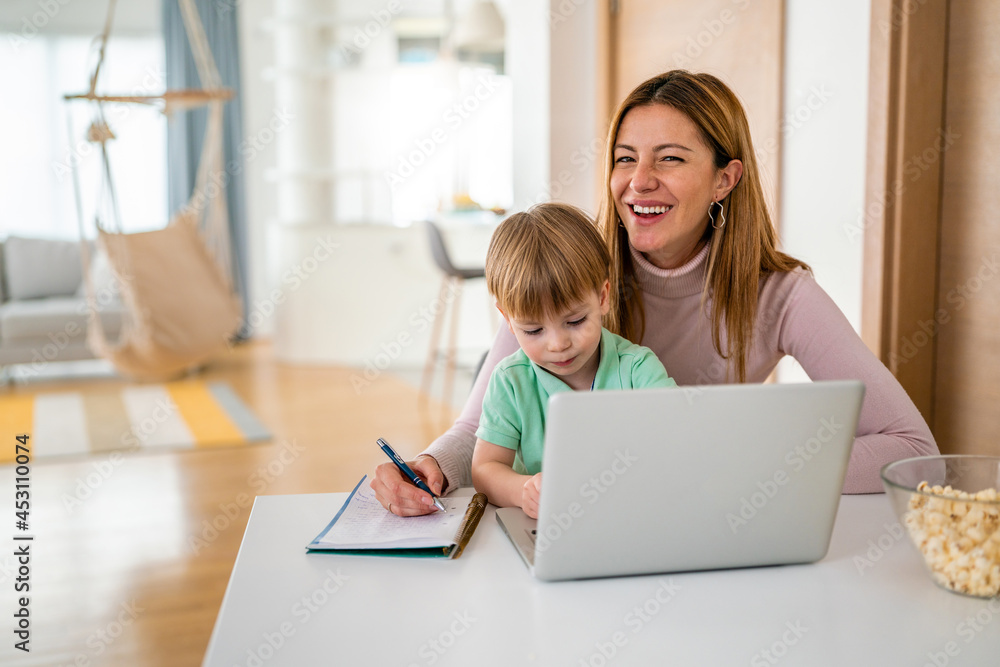 Businesswoman mother woman with a toddler working at the computer at home Businesswoman mother woman with a toddler working at the computer at home