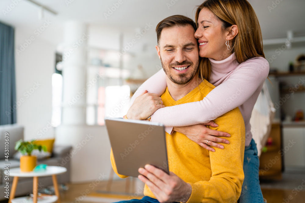 Couple in love using tablet computer at home and having fun Couple in love using tablet computer at home and having fun