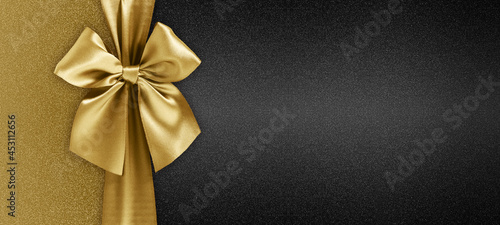 gift card with golden ribbon bow isolated on black background template with copy space for Merry Christmas or black friday promotional offer