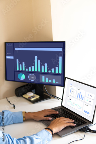 View of hands of a latin woman checking financial figures and graph reports. Top view. Business concept. Working from home. Sales and analytics, Finance.
