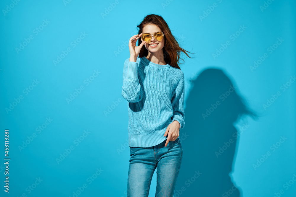 woman in a blue sweater blue background Lifestyle woman in a blue sweater blue background Lifestyle