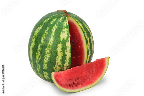 Ripe red watermelon standing upright. Nearby a slice cut out of it lies. Isolated on white background