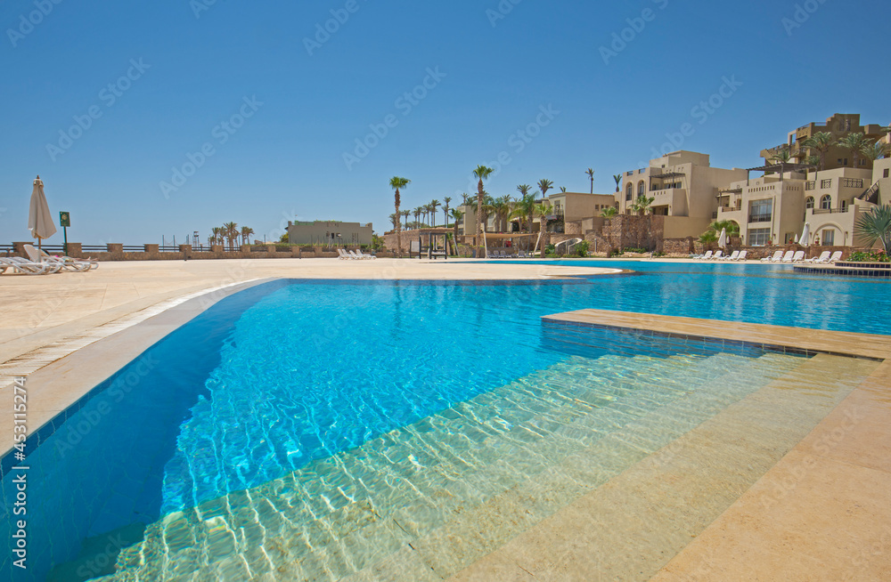 Outdoor swimming pool in a luxury tropical hotel resort Outdoor swimming pool in a luxury tropical hotel resort