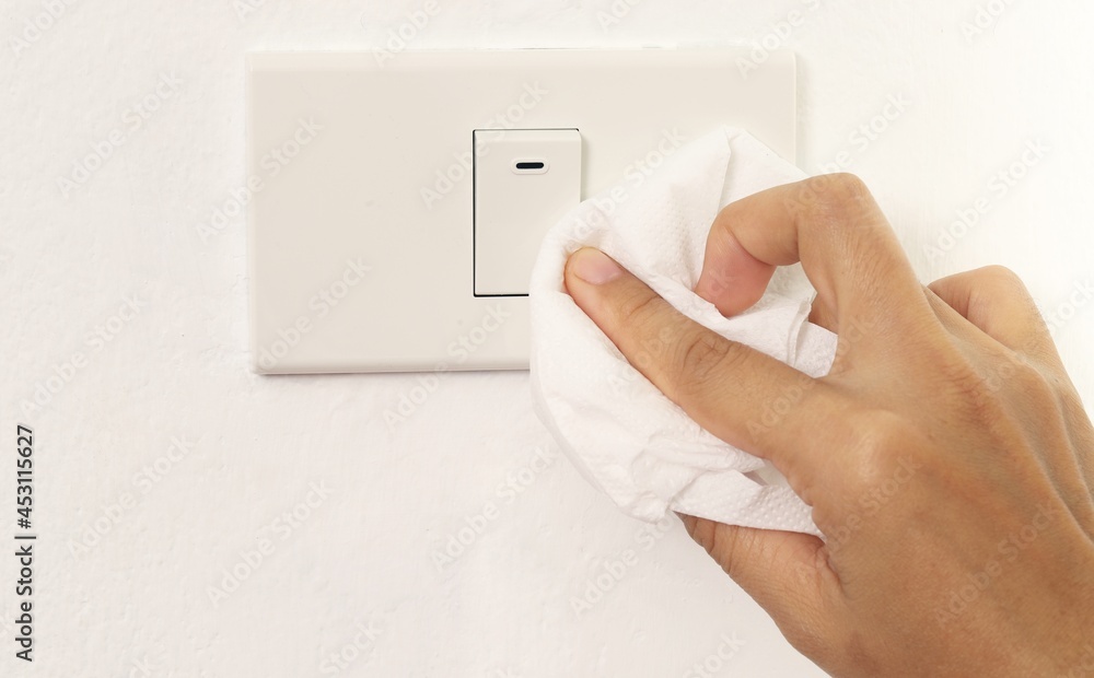 Lady cleaning the light switch in the house Lady cleaning the light switch in the house