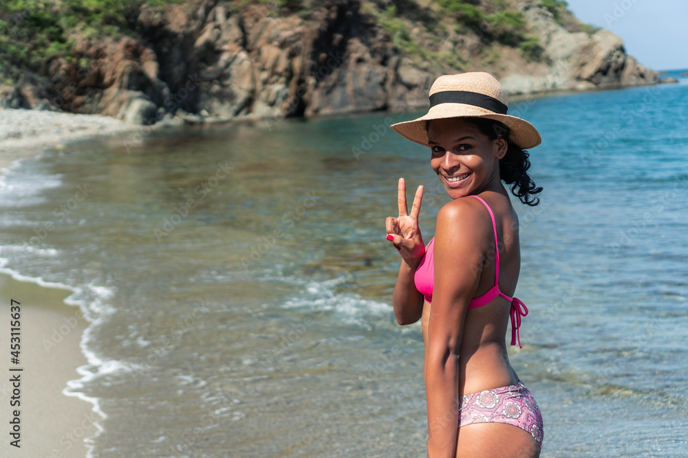 Smiling ethnic traveler in swimsuit and hat on sea beach Smiling ethnic traveler in swimsuit and hat on sea beach