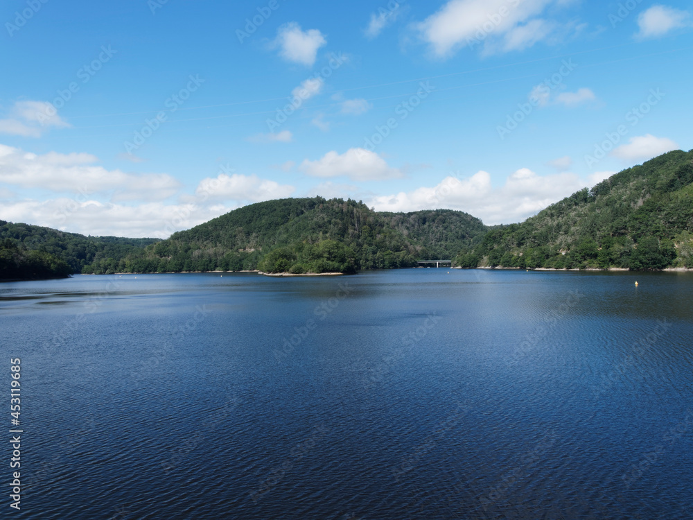 Paysage de lac en Auvergne - Patrimoine et nature des Combrailles. Plan d'eau et barrage des Fades-Besserve sous un ciel bleu d'été