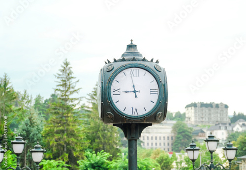 Big white street clock in the city park. Dial. Selective focus