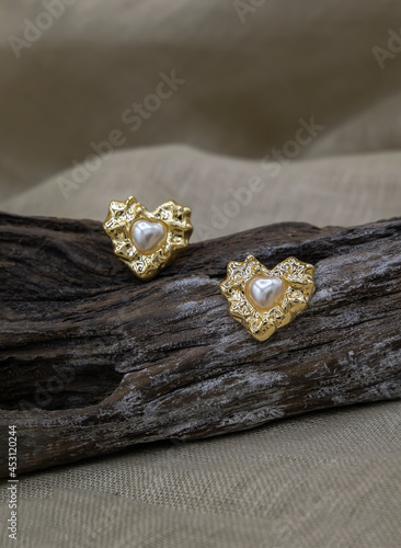 Gold jewellery setup. Silver jewelry fashion photography. Silver earrings fashion photography. Earrings presented on a timber. Women accessories. Selective focus.