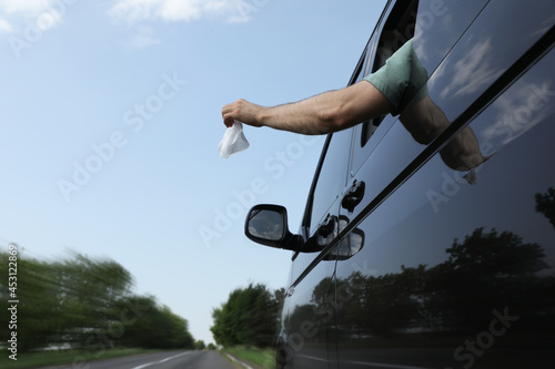 Wallpaper Mural Driver throwing away wet wipe from car window, low angle view. Garbage on road Torontodigital.ca