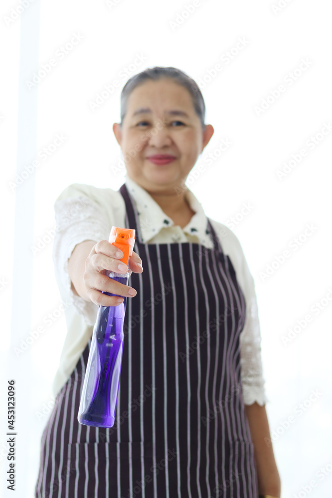 Asian senior elderly woman housewife holding cleaning spray for cleaning up house into camera, grandma doing housework. Asian senior elderly woman housewife holding cleaning spray for cleaning up house into camera, grandma doing housework.