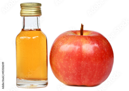 Apple and apple cider vinegar in glass bottle on white background