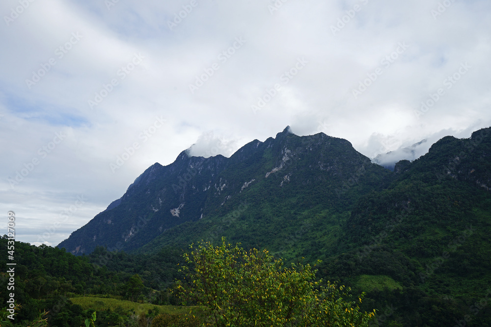 Natural landscape of green mountain range with cloudy blue sky Natural landscape of green mountain range with cloudy blue sky