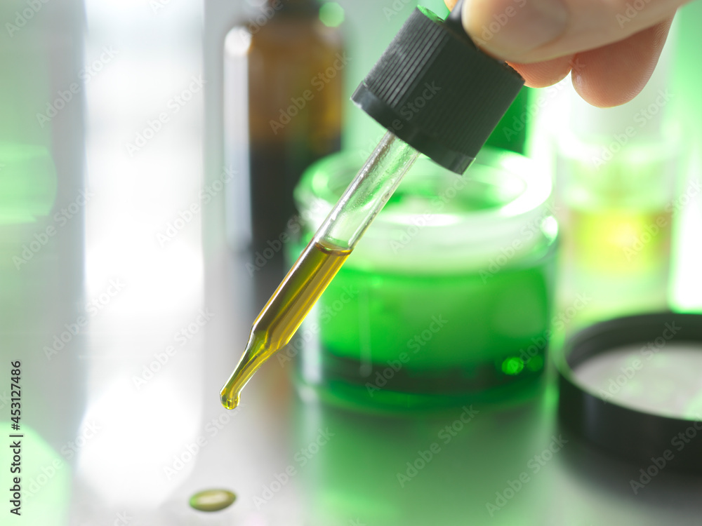 Man holding pipette with essential oil Man holding pipette with essential oil
