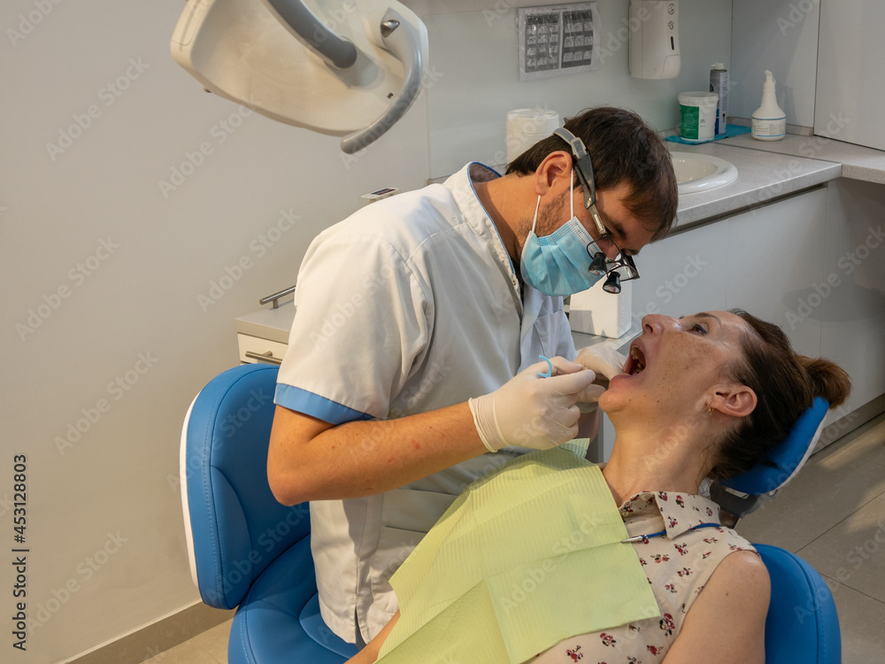 Fototapeta premium Dental clinic. Young adult woman at the dentist appointment.