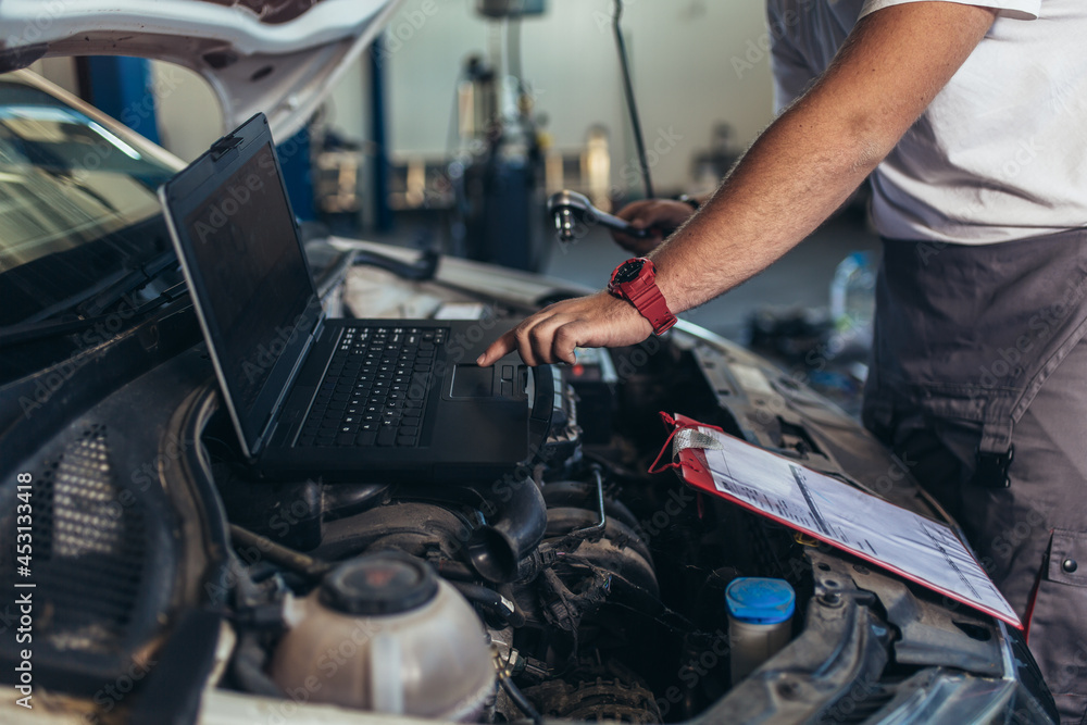 custom made wallpaper toronto digitalProfessional car mechanic working in auto repair service using laptop.