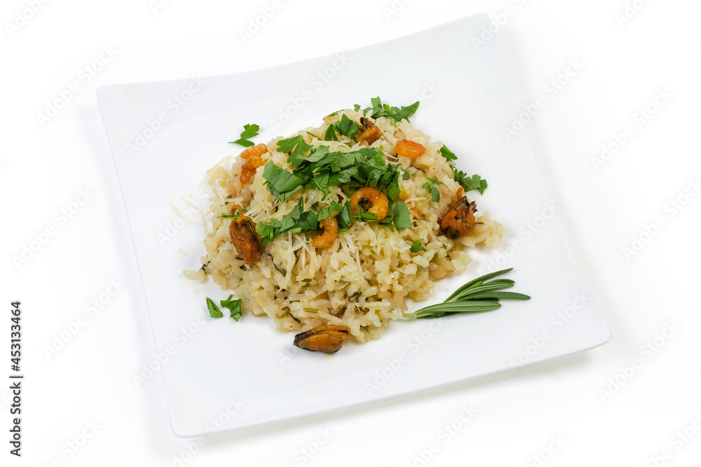 Risotto with seafood on square dish on a white background