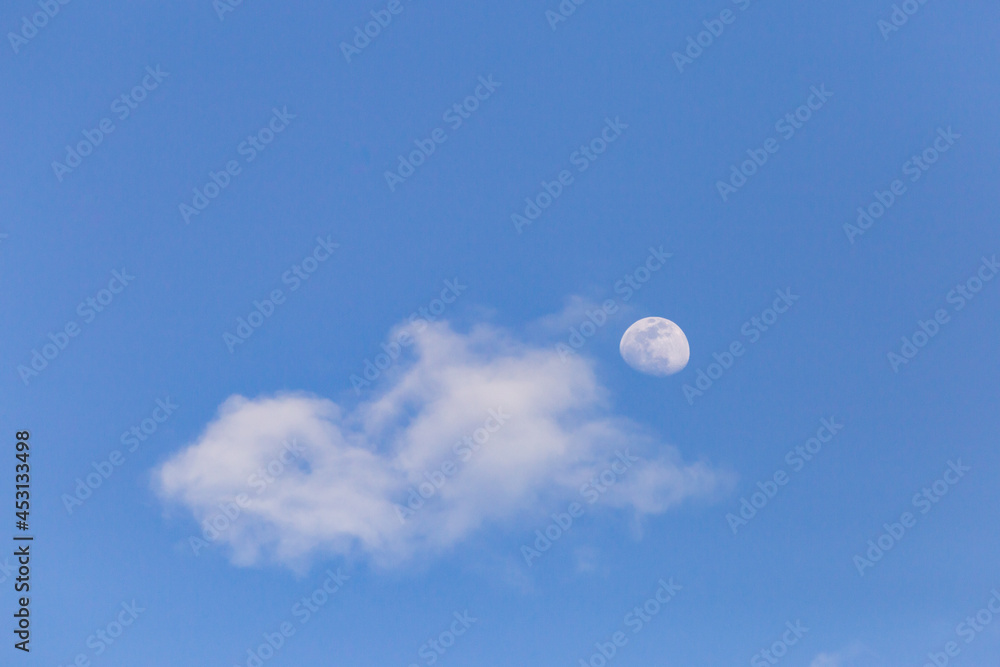 moon with white clouds blue background The afternoon moon has space for messages. moon with white clouds blue background The afternoon moon has space for messages.