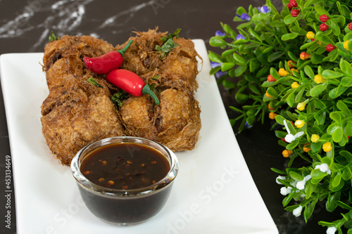 A serving of tauhu bergedil, a famous Malaysian dish with spicy soy sauce as dips. Blurred background