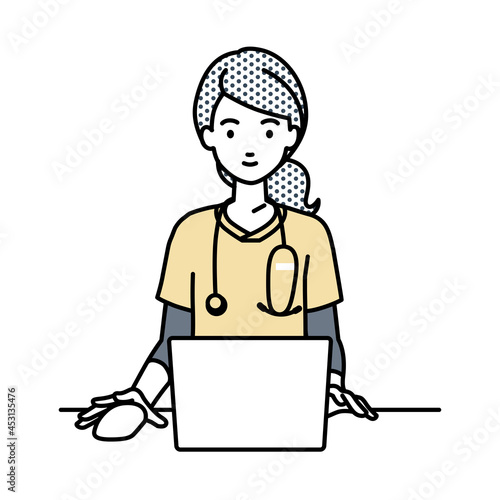 デスクで座ってPCを使っている看護師の女性