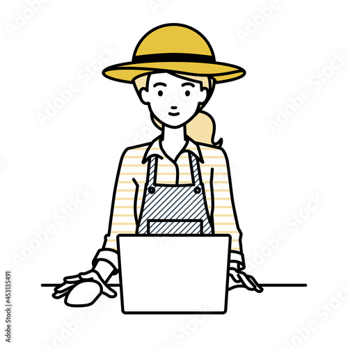 デスクで座ってPCを使っている農家の女性