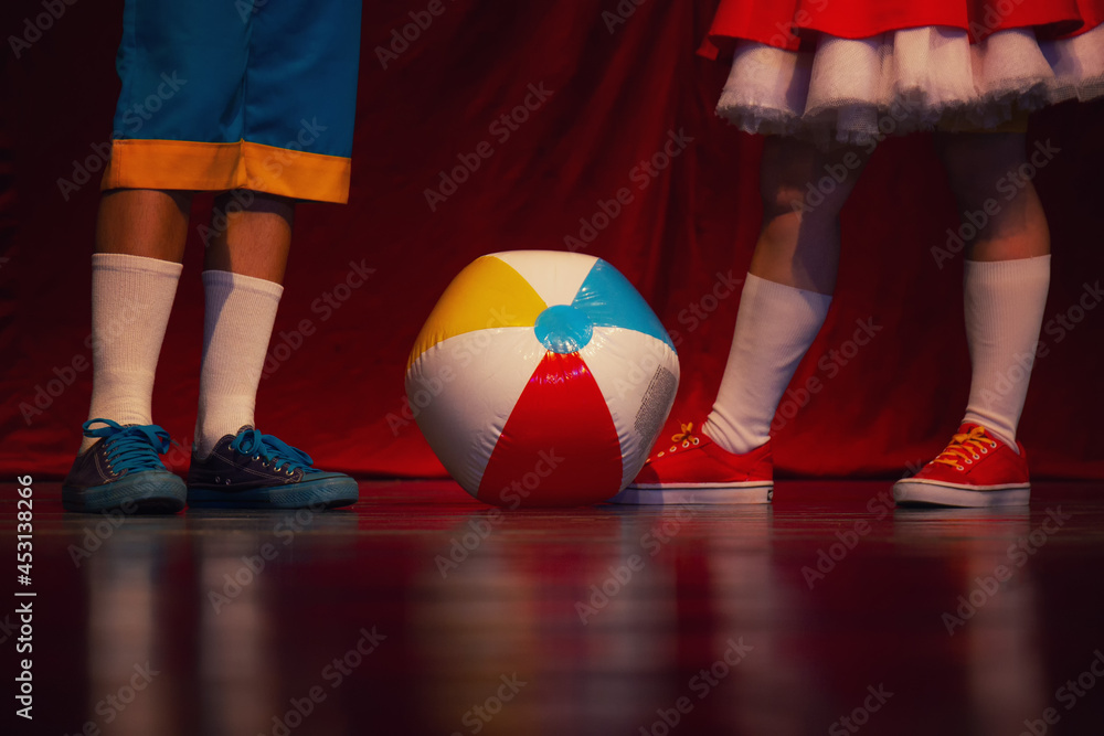 Closeup view of a girl and a boy dressed and playing wit the ball standing on the stage - obrazy, fototapety, plakaty 