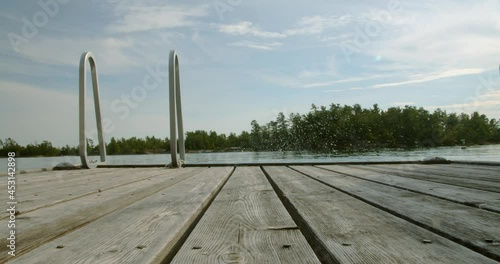 Adult male running and jumping off a dock into a lake