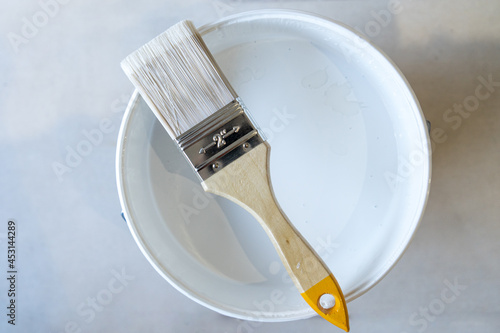 Isolated bristle brush with white paint pot
