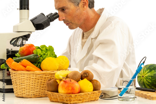 A scientific researcher in the laboratory analyzing fruit under a microscope