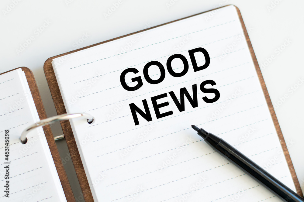 Text GOOD NEWS on a notebook on a white background - business, banking, finance and investment concept. Text GOOD NEWS on a notebook on a white background - business, banking, finance and investment concept.