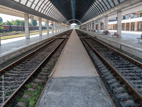 Empty train station. A platform under a glass roof.