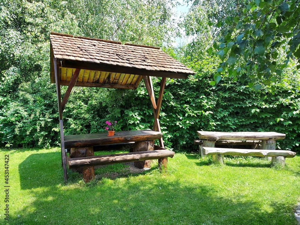 Naklejka premium Wooden tables with benches in the garden.