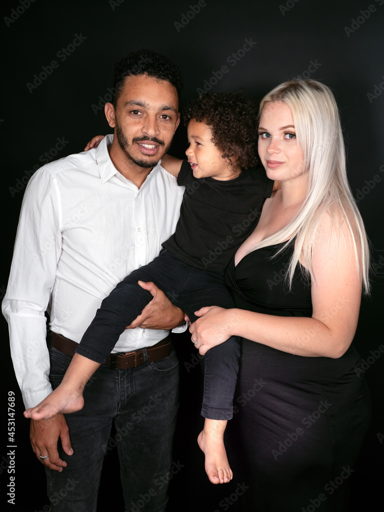 Fototapeta premium Stylish and happy multi-ethnic family expecting a baby