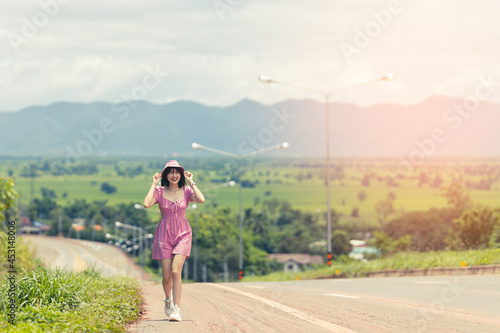 Beautiful Asian woman walking on the road and beautiful view background.
