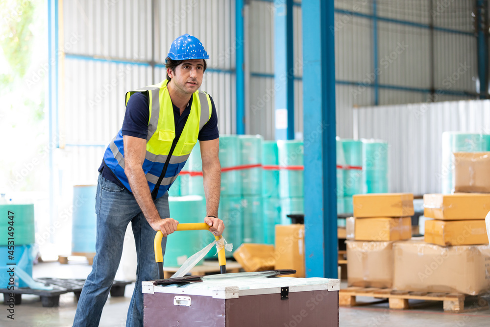 factory worker with boxes package and pushing trolley in the warehouse storage factory worker with boxes package and pushing trolley in the warehouse storage
