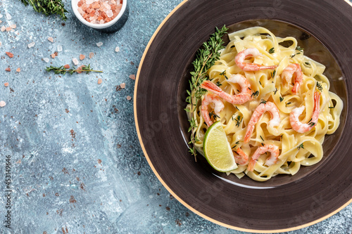 tasty pasta with shrimps, Italian pasta fettuccine with grilled shrimps, bechamel sauce and thyme, banner, menu recipe place for text, top view