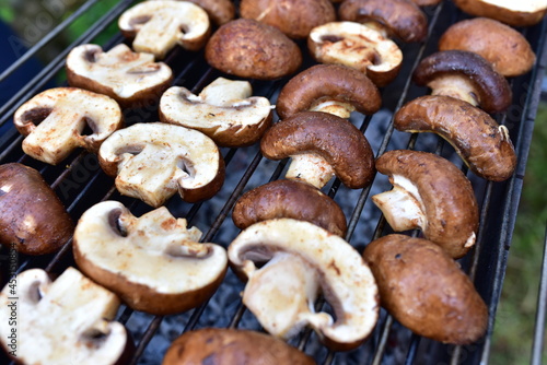 Champignon Mushroom on grilled. Cooking Agaricus bisporus White Mushrooms ​on hot charcoal and fire. Barbecue grill vegetables on flames.