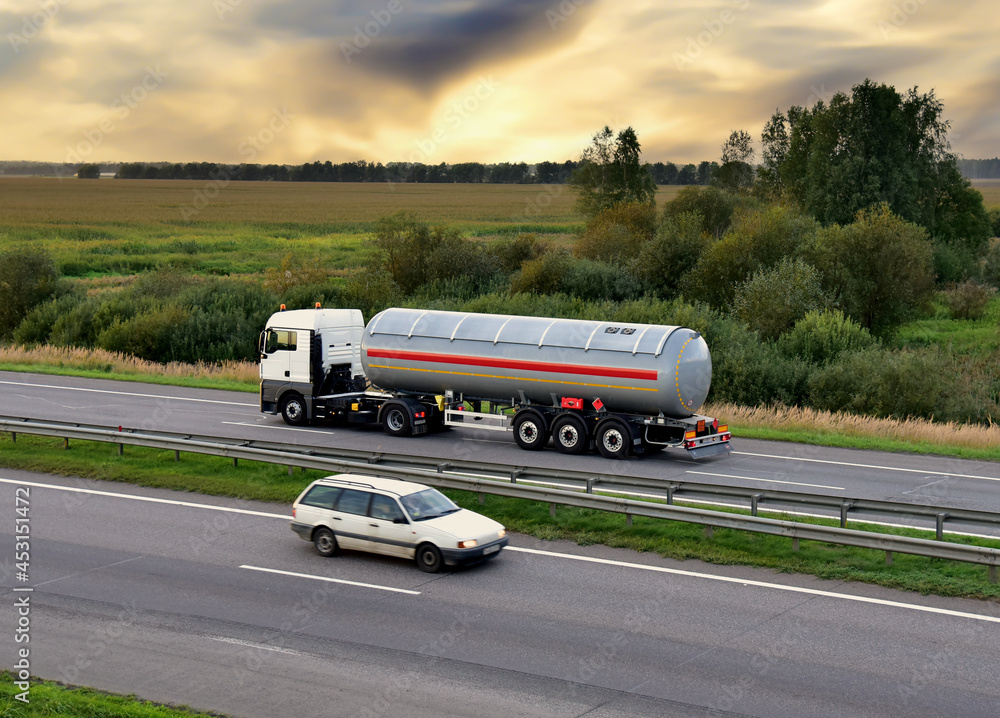 Isothermal Tank truck driving on highway. Oil and Gas Transportation and Logistics. Metal chrome cistern tanker with petrochemicals products. Liquid Chemical Freight. Out of focus Isothermal Tank truck driving on highway. Oil and Gas Transportation and Logistics. Metal chrome cistern tanker with petrochemicals products. Liquid Chemical Freight. Out of focus