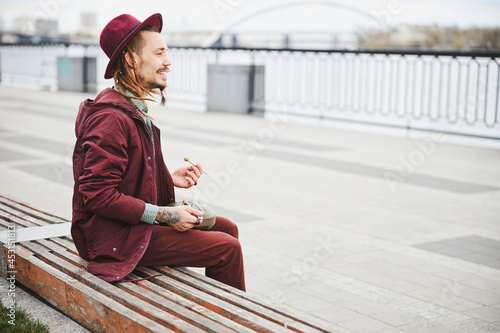 Relaxed male creating melody on the embankment © Svitlana