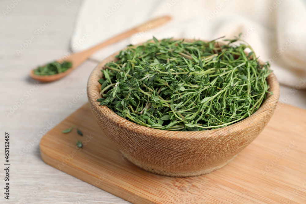 Aromatic thyme in bowl on white wooden table, closeup Aromatic thyme in bowl on white wooden table, closeup