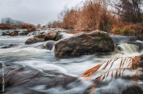 Mountain fast wild river for rafting. A large stone in the river in the foreground. River landscape in autumn. photo