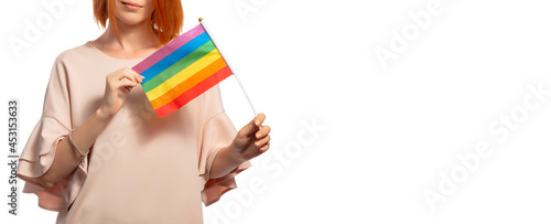 LGBT flag held by woman in dress isolated on white background. Banner, place for text. The concept of freedom, rights of persons with different sexual orientations.